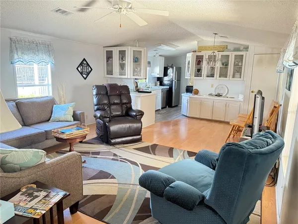 a living room with furniture kitchen view and a window