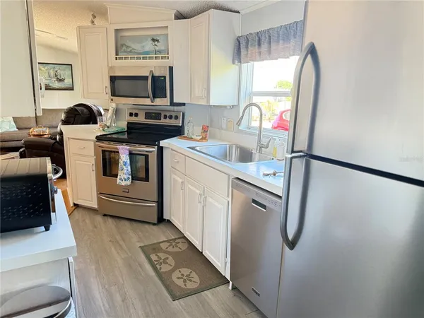 a kitchen with a refrigerator and a stove top oven