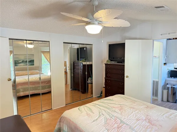 a bedroom with a bed and a large mirror on the dresser