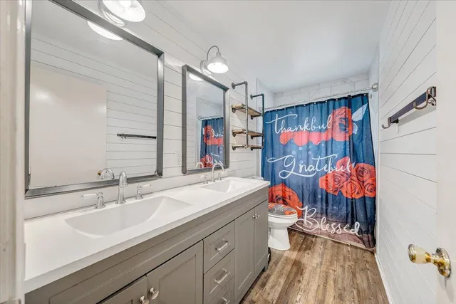a bathroom with stainless steel appliances a sink and a mirror