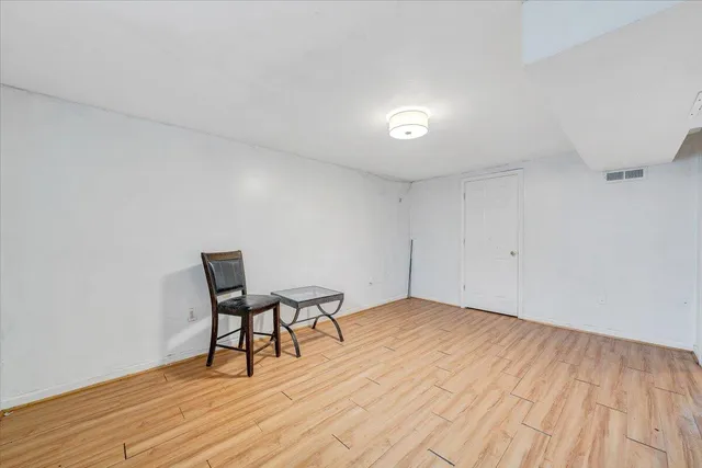 a view of a room with wooden floor and a chair