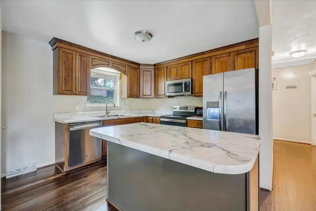 a kitchen with stainless steel appliances granite countertop a sink stove and refrigerator