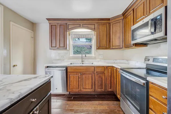 a kitchen with stainless steel appliances granite countertop a sink stove and cabinets