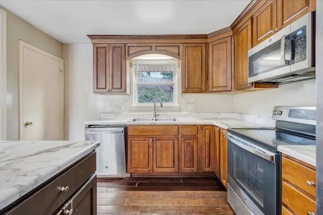 a kitchen with stainless steel appliances granite countertop a sink stove and cabinets