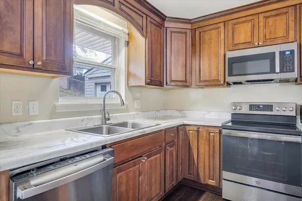 a kitchen with granite countertop a sink stainless steel appliances and cabinets
