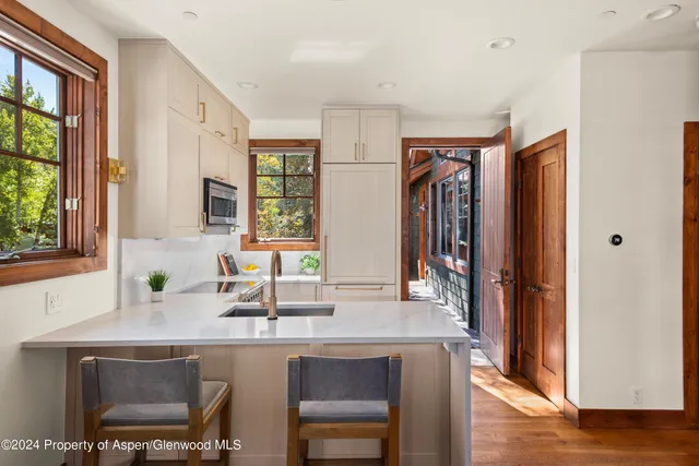 a kitchen with stainless steel appliances granite countertop a sink and a refrigerator