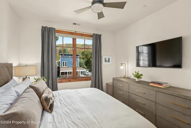 a bedroom with a bed and a flat screen tv