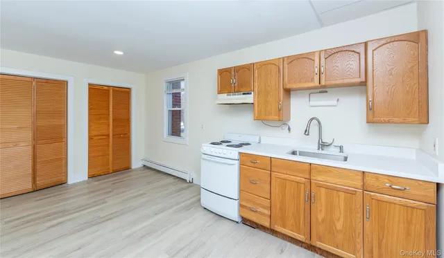 a kitchen with stainless steel appliances a sink cabinets and wooden floor