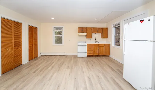 wooden floor in an empty room with a kitchen