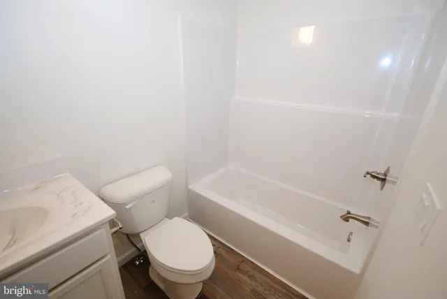 a white toilet and tub sitting next to a bathroom sink