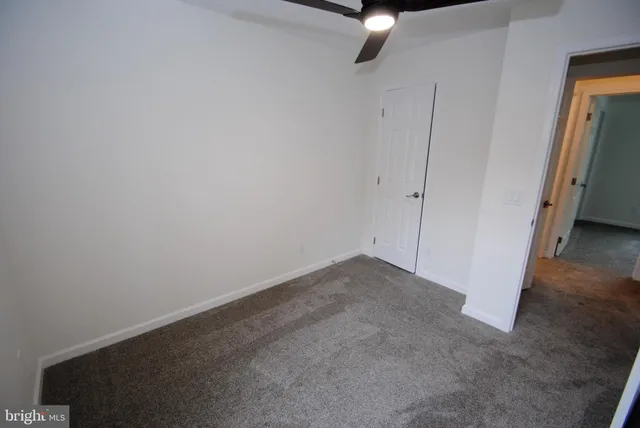 a view of a room with a ceiling fan and window