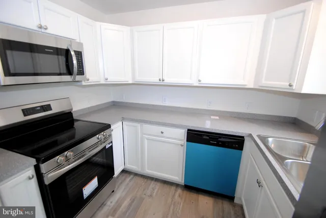 a kitchen with a microwave stove top oven and sink
