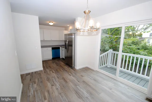 a view of a room with wooden floor staircase and kitchen view