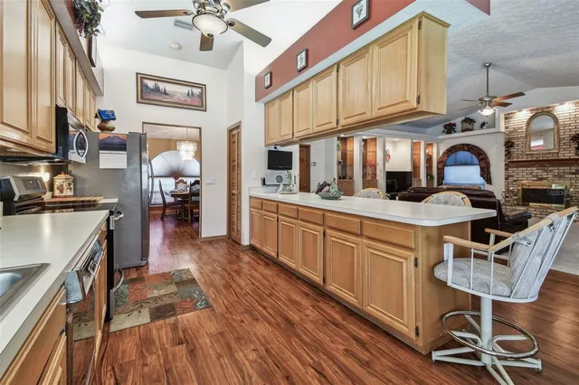 a large kitchen with stainless steel appliances granite countertop a large stove top oven a sink dishwasher and a microwave oven with cabinets