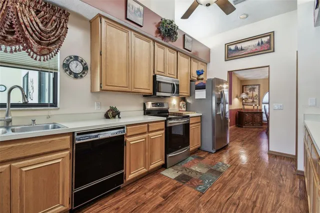 a kitchen with stainless steel appliances a stove a sink dishwasher and cabinets with wooden floor