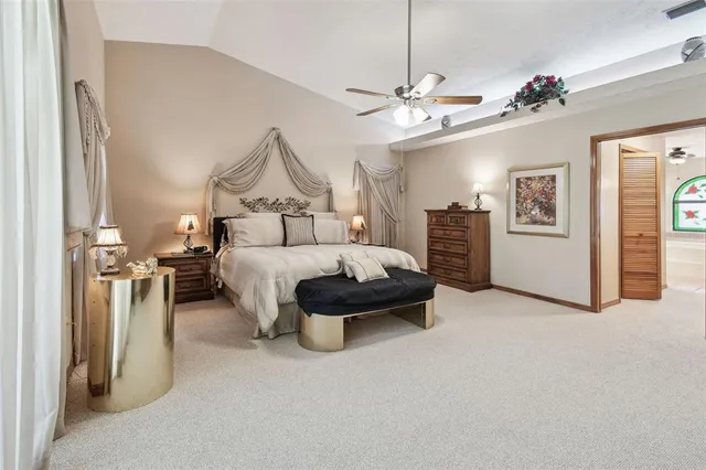 a spacious bedroom with a bed and dresser with mirror