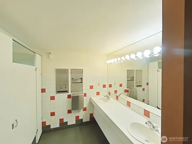 a bathroom with a double vanity sink mirror and shower