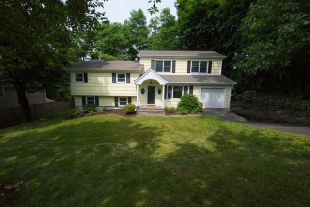 a front view of a house with a garden and trees