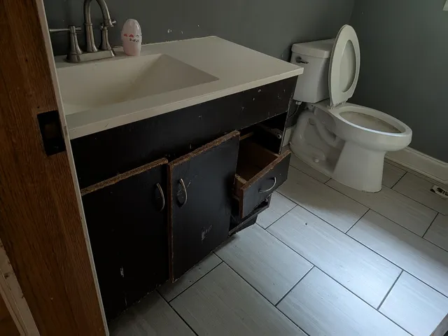 a bathroom with a toilet a sink and mirror
