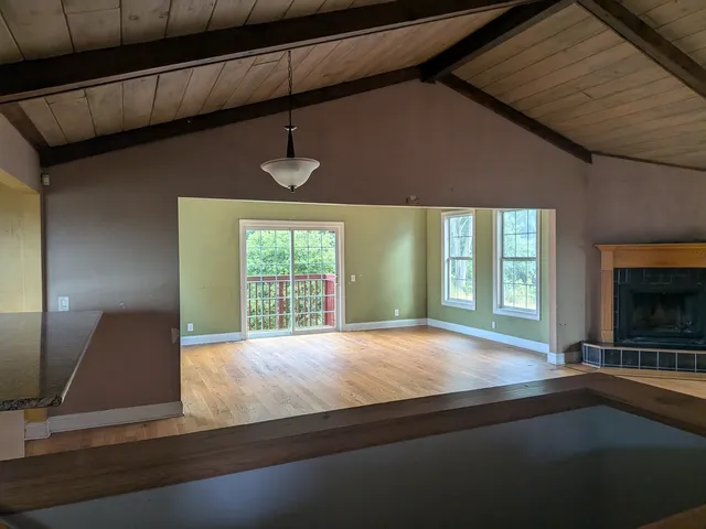 a view of an empty room with a fireplace and a window