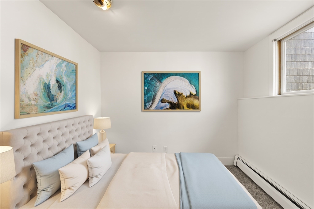 22 Taylor Street, Unit 1 Gloucester, MA 01930 - Photo 12 of 31 a bedroom with a bed and a painting on the wall