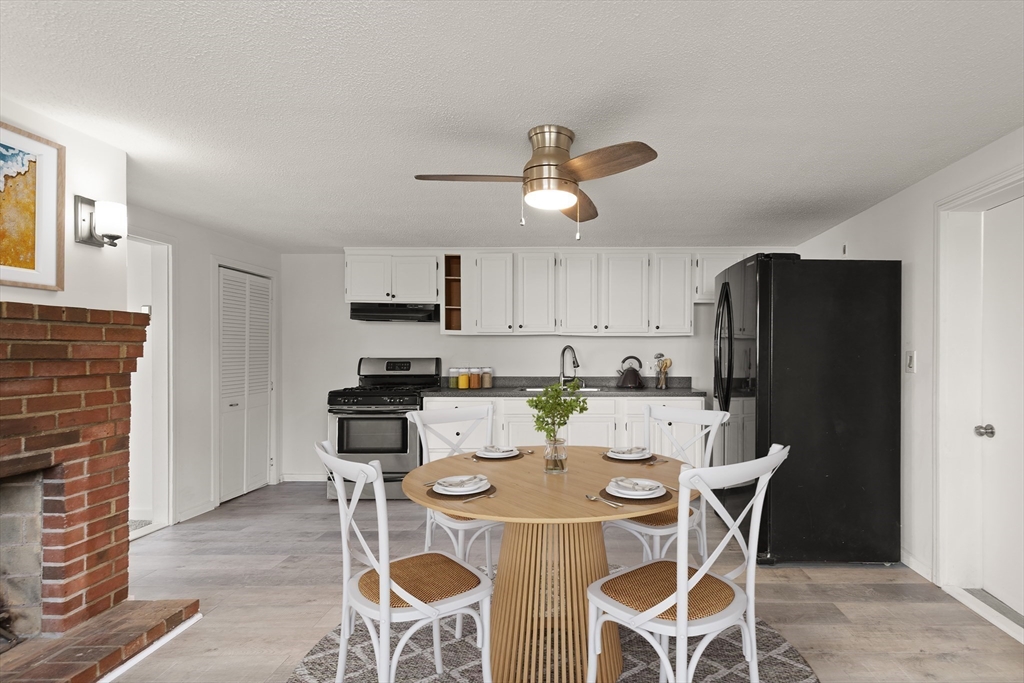 22 Taylor Street, Unit 1 Gloucester, MA 01930 - Photo 6 of 31 a kitchen with stainless steel appliances kitchen island granite countertop a dining table and chairs