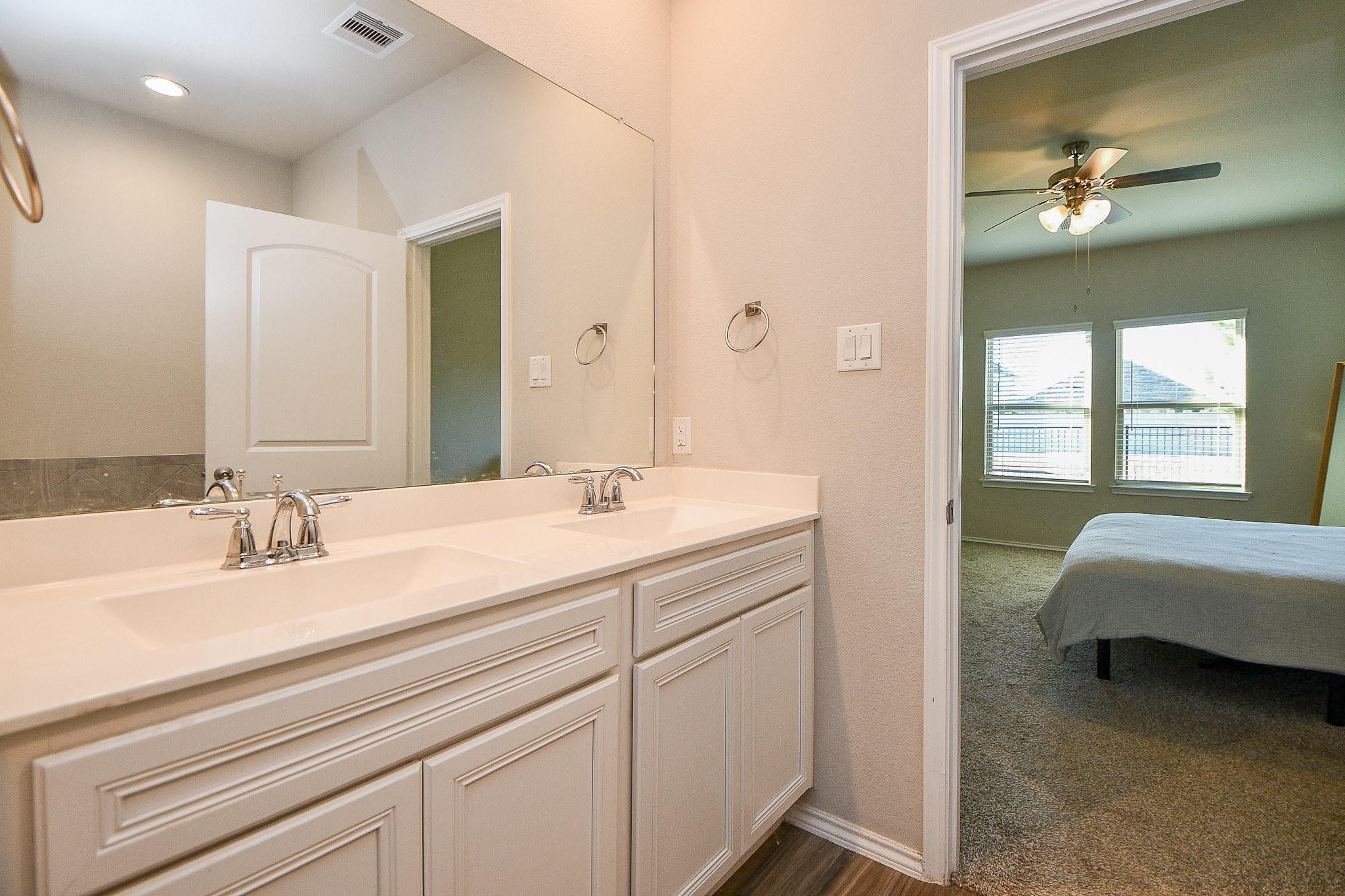 16868 Pink Wintergreen Drive Conroe, TX 77385 - Photo 19 of 32 a en suite bathroom with a double vanity sink and a mirror