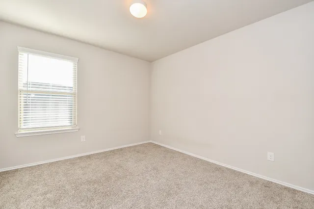 a view of a room with a white wall and a window