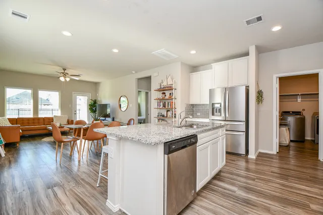 a kitchen with stainless steel appliances granite countertop a sink stove and cabinets