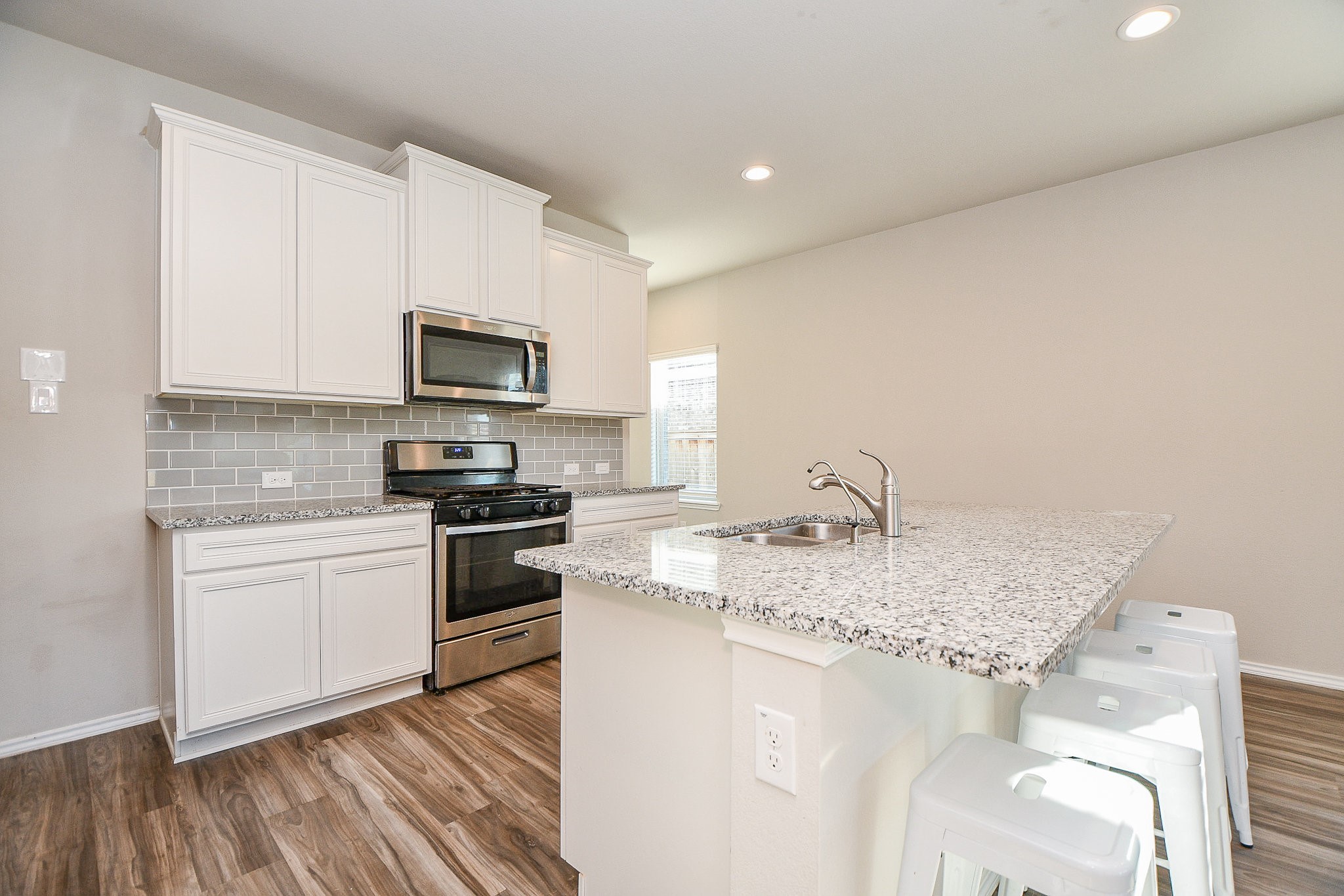 16868 Pink Wintergreen Drive Conroe, TX 77385 - Photo 7 of 32 a kitchen with a sink stove and microwave
