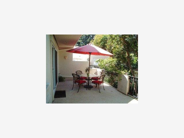 20 Willow Road, Unit 7 Menlo Park, CA 94025 - Photo 9 of 9 a view of a living room with a table and chairs under an umbrella