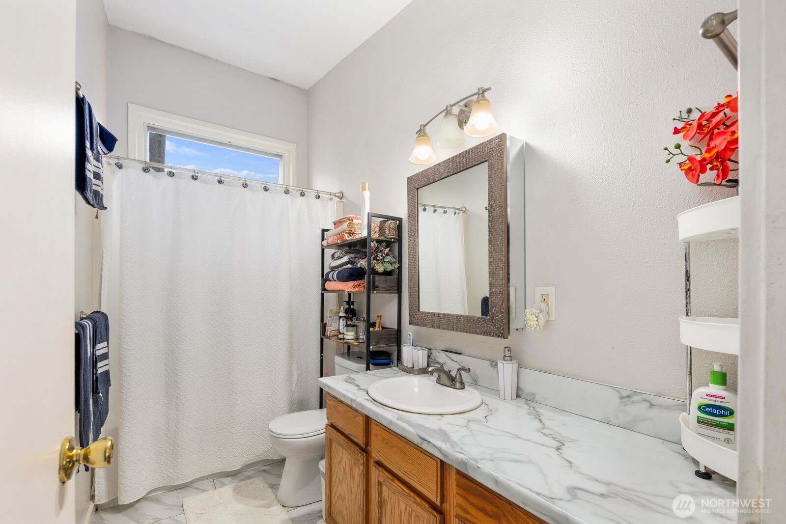 9452 25th Avenue Southwest Seattle, WA 98106 - Photo 19 of 37 a bathroom with a granite countertop sink and a mirror