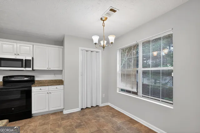 a kitchen that has a lot of cabinets and wooden floor