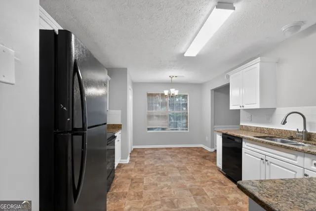 a kitchen with stainless steel appliances granite countertop a refrigerator a sink a stove and dishwasher