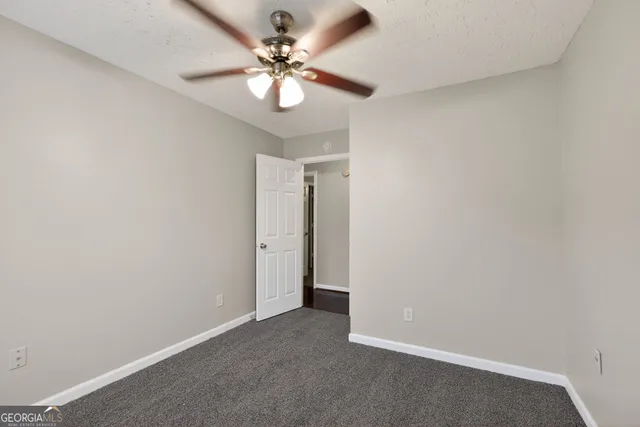 an empty room with a fan and a fan