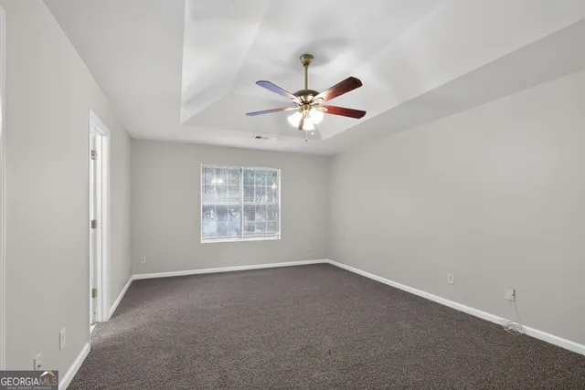 an empty room with a window and a fan
