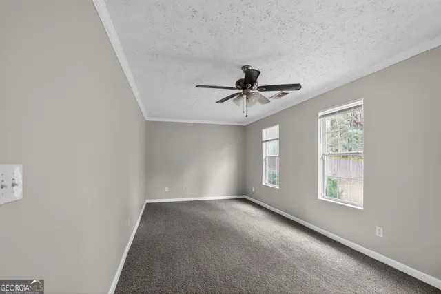 a view of a livingroom with a ceiling fan and window