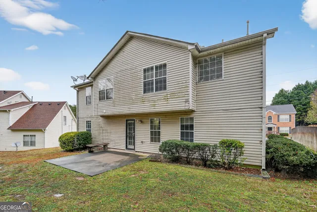 a front view of a house with a yard and potted plants