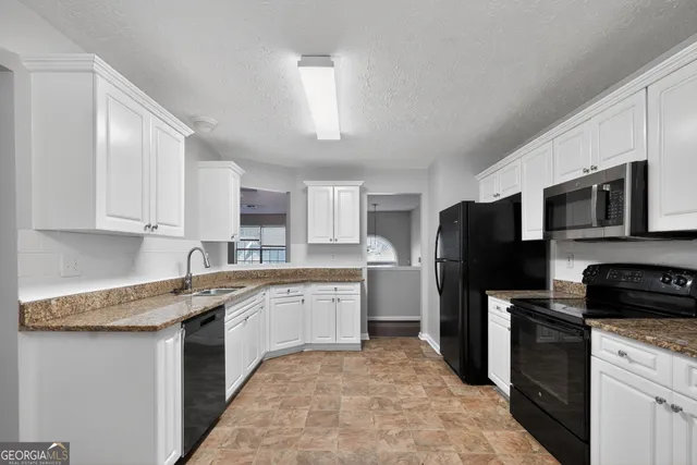 a kitchen with a sink a microwave a refrigerator and cabinets