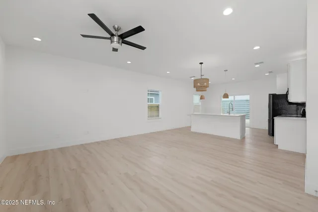 a view of a livingroom with a ceiling fan and wooden floor