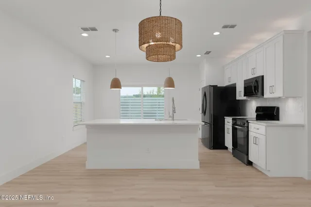 a kitchen with stainless steel appliances granite countertop a refrigerator a stove a sink and a microwave