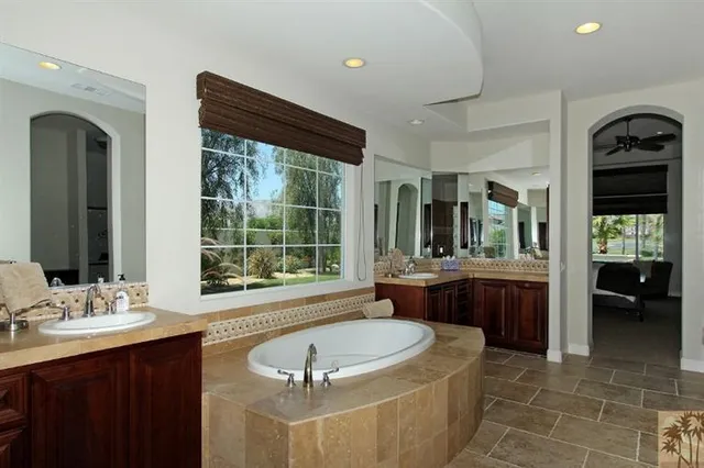 a bathroom with a tub sink and mirror