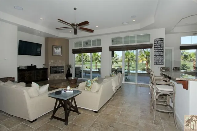 a living room with furniture a flat screen tv and a large window