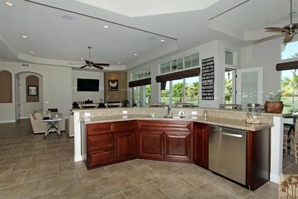 a large kitchen with stainless steel appliances a sink and cabinets