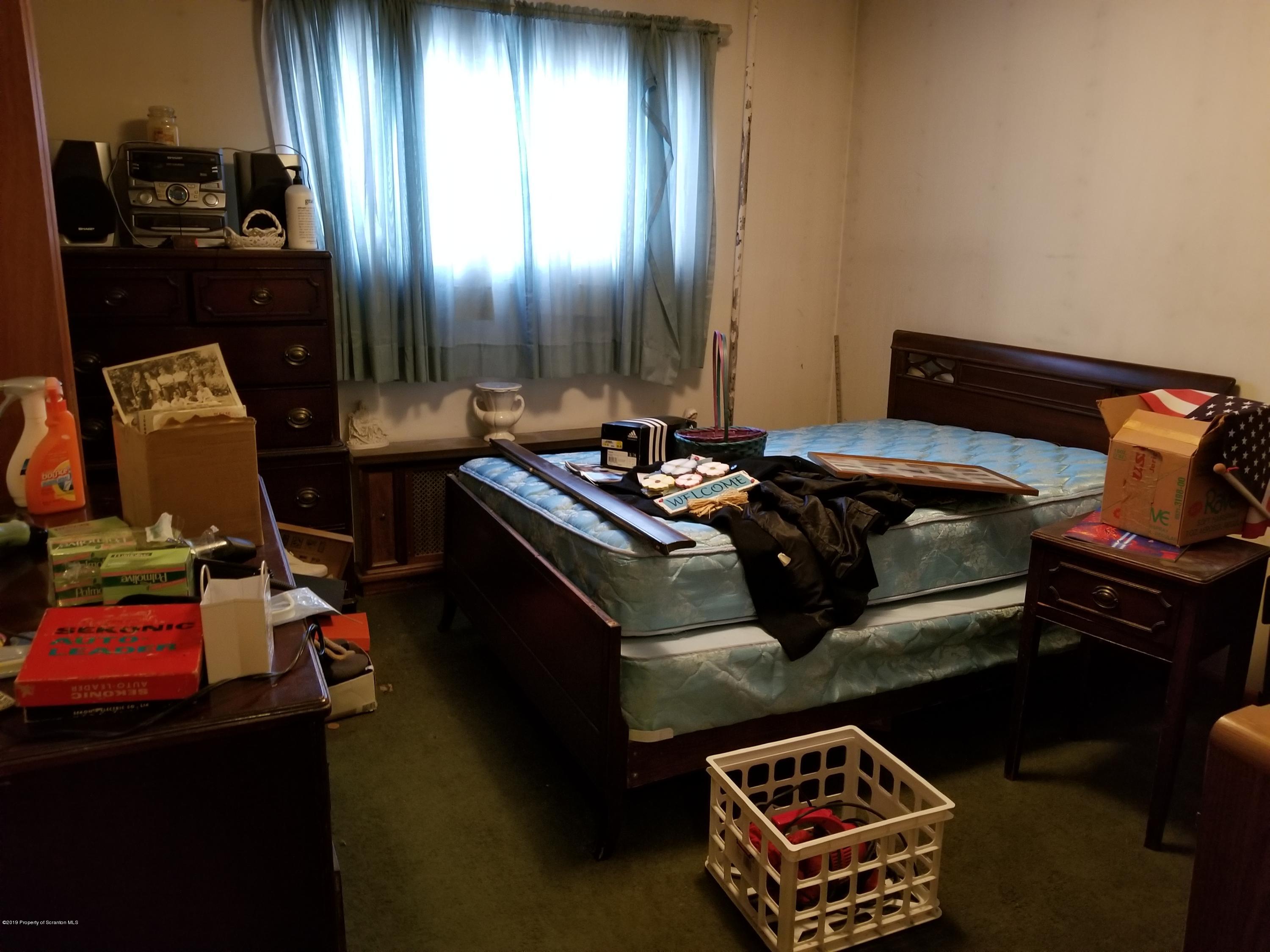 1719 Ash Street Scranton, PA 18510 - Photo 8 of 19 a bed sitting in a bedroom next to a window