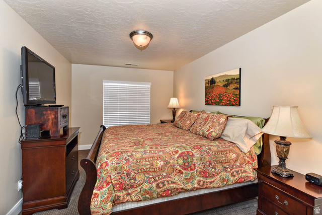 1622 Canyon Tree Drive St. George, UT 84770 - Photo 16 of 34 Carpeted bedroom featuring a window with blinds, a ceiling-mounted light fixture, and neutral wall tones