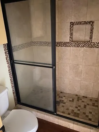 a view of an empty room with wooden floor and closet