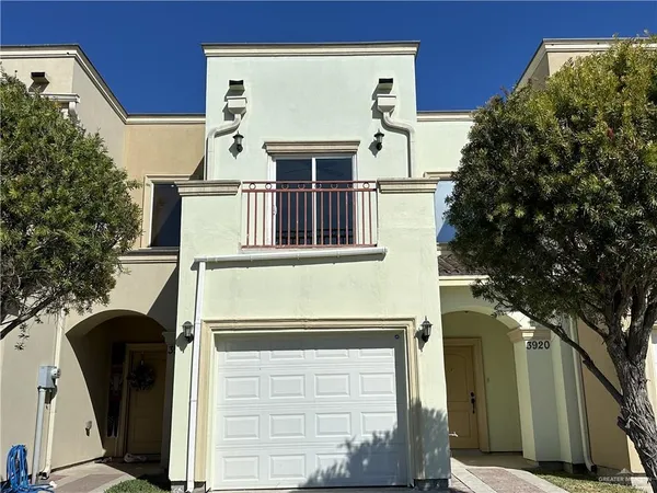 a view of a house with a door and a tree