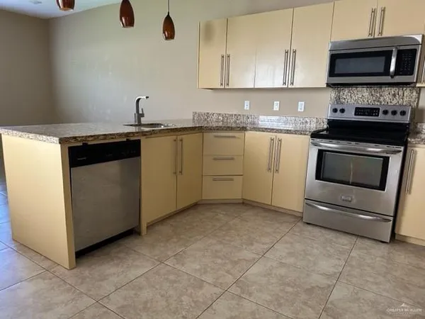 a kitchen with stainless steel appliances granite countertop a stove a sink and a microwave
