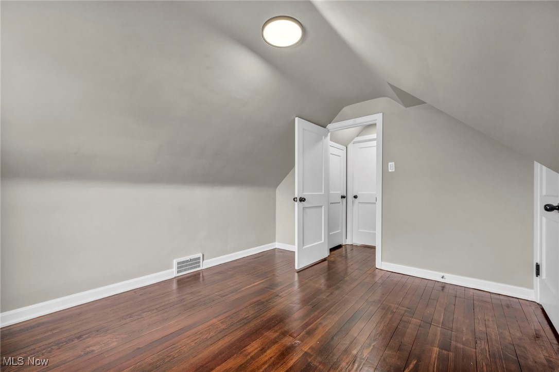 13614 Cedar Road Cleveland, OH 44118 - Photo 34 of 46 Additional living space with visible vents, vaulted ceiling, baseboards, and dark wood finished floors